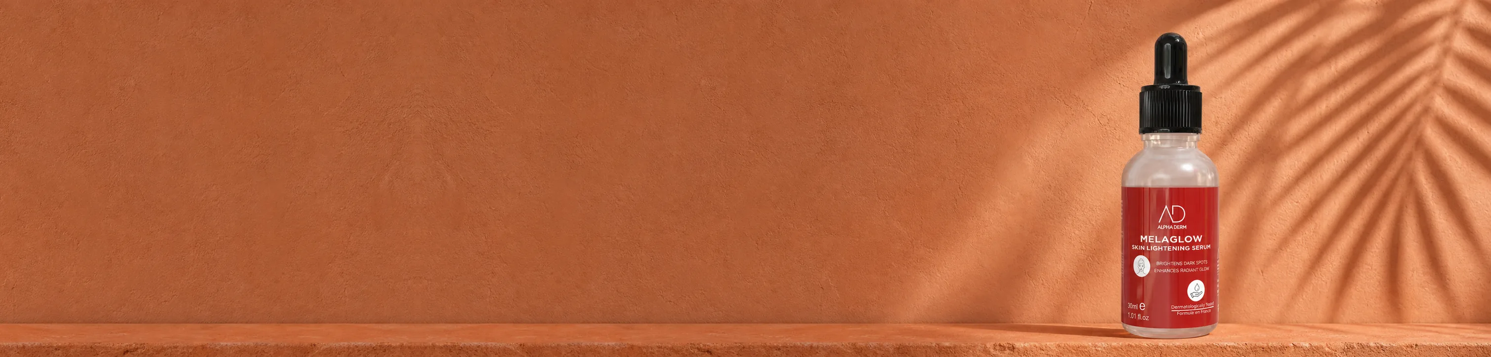 MELAGLOW Serum on a terracotta ledge under palm-frond shadow