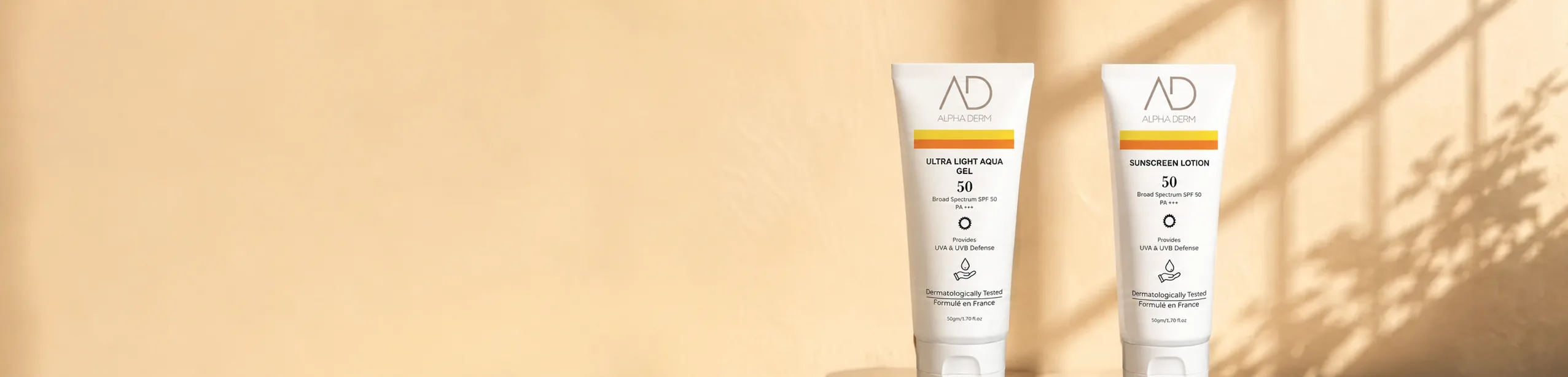 Ultra Light Aqua Gel and Sunscreen Lotion tubes on warm travertine in window light